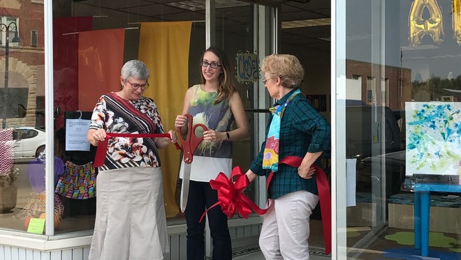 From left, Gloria Dovre, Christiana Hovick and Bobbi Jo Van Deusen during the ribbon cutting at the new art studio and school, Colorful, in downtown Williamsburg.