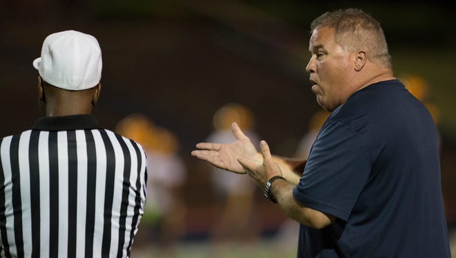 Escambia High School head football coach Mike Bennett chats with a referee during the preseason game against Catholic High School in Pensacola on Friday, August 18, 2017.