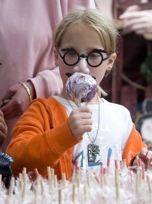 Kayla Prosinski, 8, of Endwell picks a grape-flavored candied apple at the Cider Mill booth during a past Endicott Apple Festival on Washington Avenue Saturday in Endicott. Booths and stands with crafts, food, and entertainment lined Washington Avenue for the event sponsored by Washington Avenue Business and Professional Association.