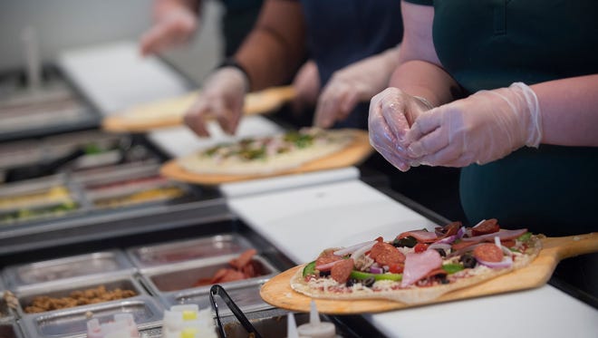 Employees make pizzas during a media event at the store on Wednesday, Sept. 7, 2016, in Montgomery, Ala. The store is scheduled to open on Sept. 8, 2016. 