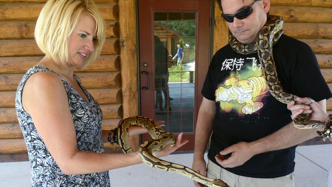 Lisa Powers challenges herself to overcome her fear of snakes at Appleton’s Butterfly Gardens of Wisconsin on June 27.