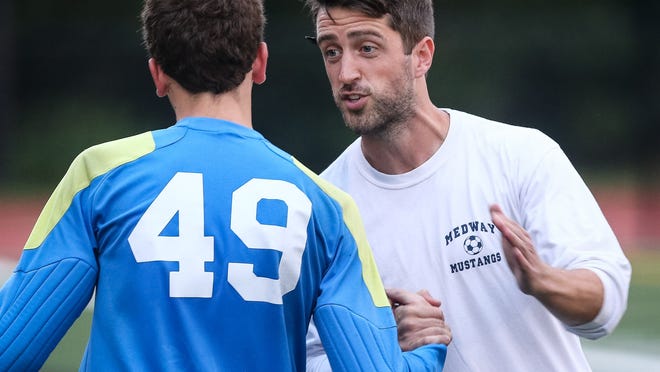 Neill Brandon (right) speaks with former Medway High goalie Graham Phenegar during a boys soccer game against Norton at Medway High School in. Brandon recently stepped down as the head coach of the Mustangs program.