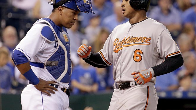 Baltimore Orioles' Jonathan Schoop (6) runs past Kansas City Royals catcher Salvador Perez to score after hitting a two-run home run during the fourth inning Wednesday in Kansas City.