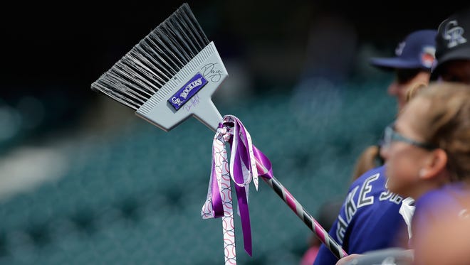 A fan carries a broom in the hope of a series sweep by the Colorado Rockies against the Arizona Diamondbacks at Coors Field on September 21, 2014 in Denver, Colorado.