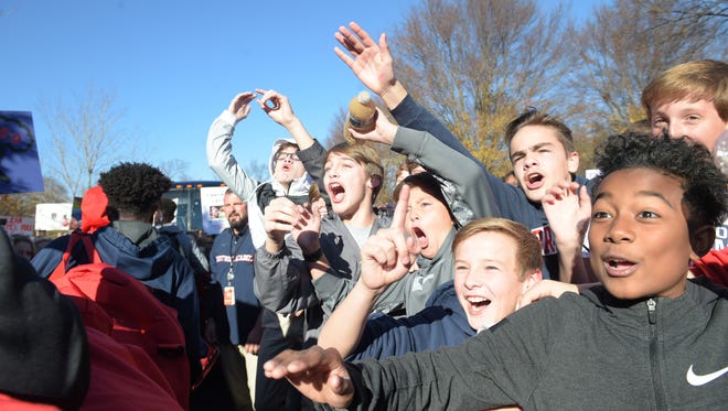 Brentwood Academy student Fai Wong- Ken,13, right and other students cheer as the football players load the bus for the state championships game on Thursday, Dec. 1, 2016. 