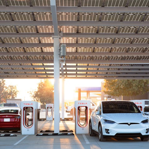 Several Teslas parked at a Supercharger station.