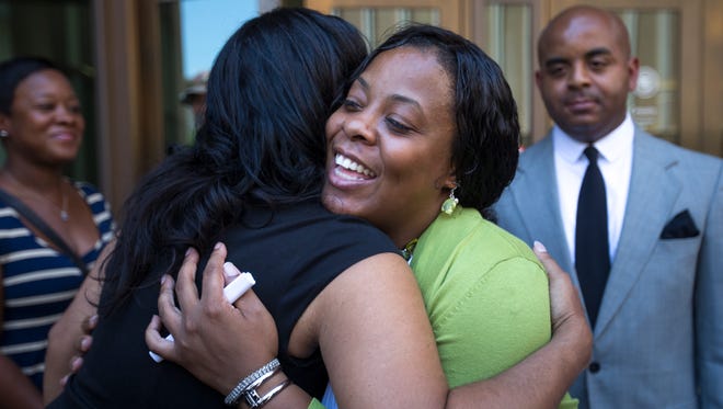 Shanesha Taylor gets hugs from her supporters following her settlement with the Maricopa County Attorney's Office. Taylor must complete a diversion program to have the child-abuse charges dropped. She was charged in March for leaving her children in the car in Scottsdale applying for a job.