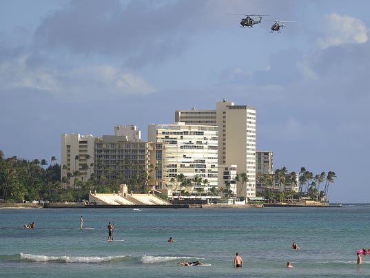 Helicopters patrol over Waikiki beach as