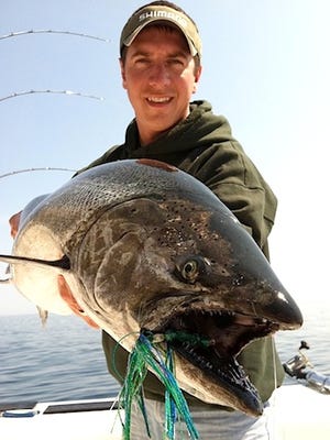 Troy Mattson holds the "king" of Lake Michigan, a chinook salmon.