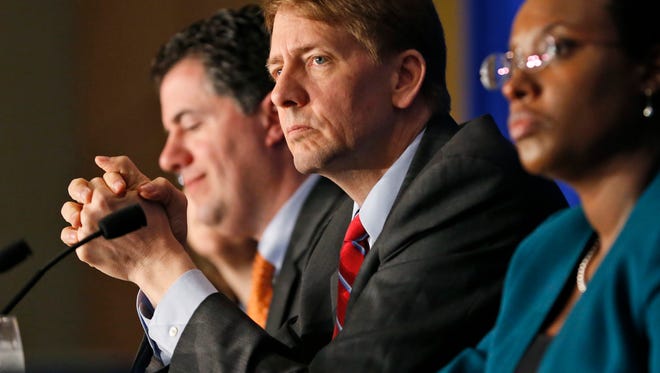 In this Thursday, March 26, 2015, file photo, Consumer Financial Protection Bureau Director Richard Cordray, center, listens to comments during a panel discussion in Richmond, Va.