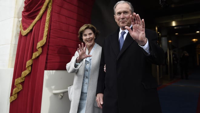 Former President George W. Bush and his wife Laura Bush wave as they arrive on Capitol Hill in Washington, Friday, Jan. 20, 2017, for the presidential inauguration of Donald Trump. (Saul Loeb via AP, Pool)