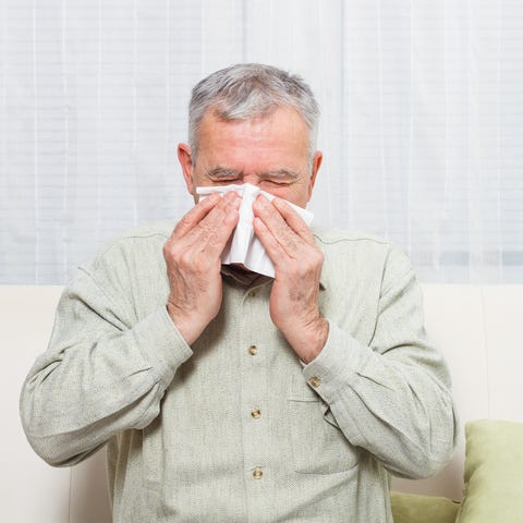Senior man blowing his nose