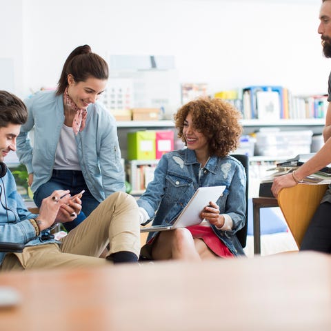 Millennial workers around a conference table using