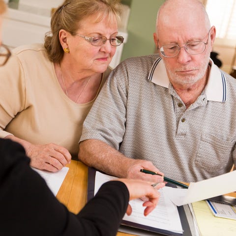 Older couple reviewing paperwork with the help of 