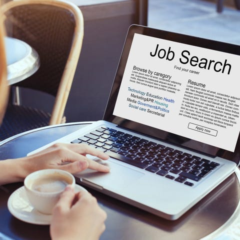 Woman at a laptop, with a job-search page on-scree
