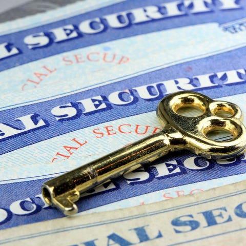 Three Social Security cards with a brass key on to