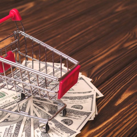 A mini shopping cart with cash underneath.