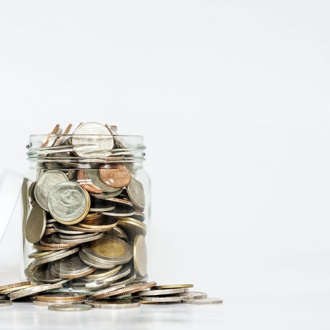 Glass jar overflowing with coins