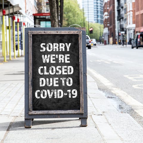 A foldable sign in front of a store that reads, So