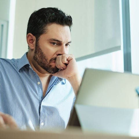 Worried man looking at a laptop screen.