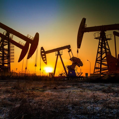 Oil wells with a setting sun in the background