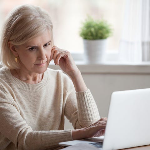 Older woman with serious expression at laptop