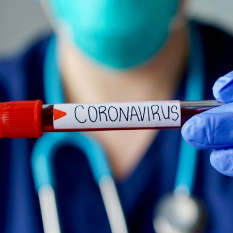 A doctor holding a coronavirus test tube.