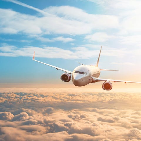 A plane flies above the clouds.