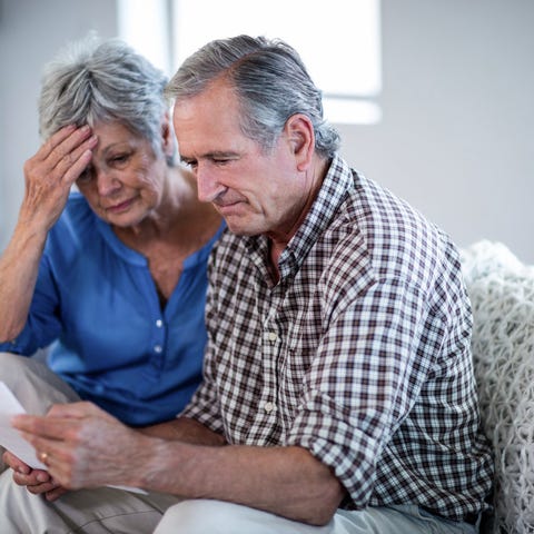 Older couple feeling worried and looking at docume