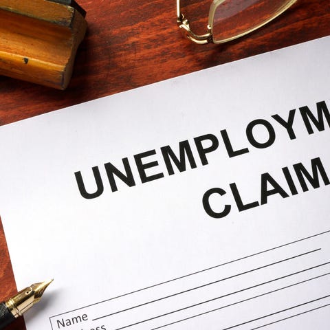 Unemployment claim document on table with open pen