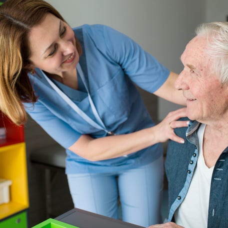A caregiver checking in on an older adult.