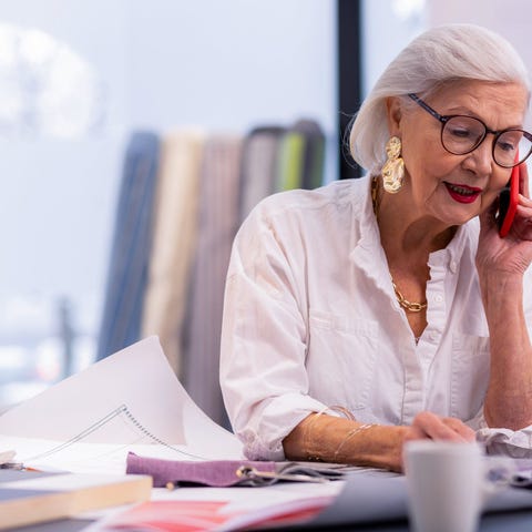 Older lady on the phone working in an office.