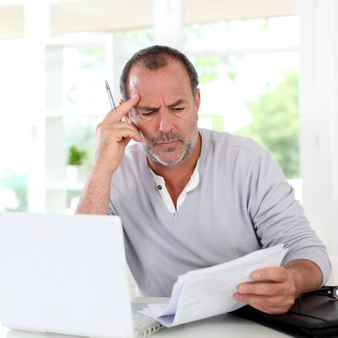 Mature man looking at paper documents in front of 