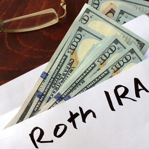 Envelope labeled Roth IRA with hundred-dollar bill