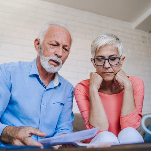 Older man and woman with serious expressions looki