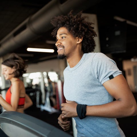 A man and a women running on treadmills in a gym