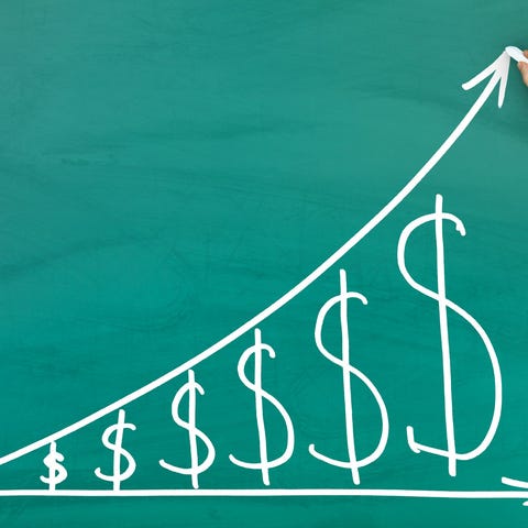 A chalkboard displays a graph that shows dollar si