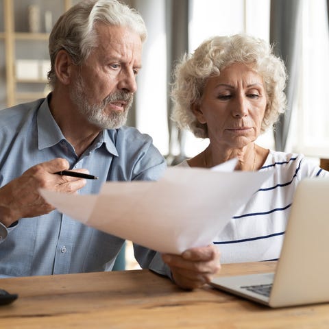 Older man and woman at laptop with concerned expre