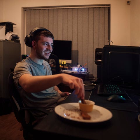 A young male gamer looking at a computer screen an