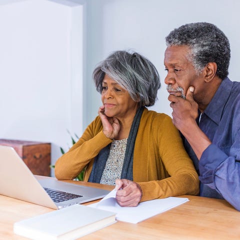 Older couple looking at laptop with concerned expr