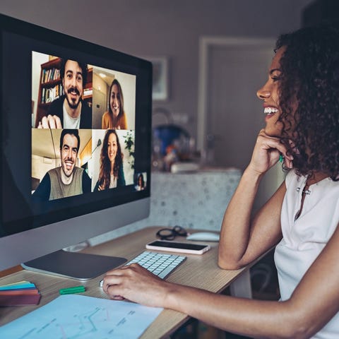 A young woman chats to her friends on a video conf