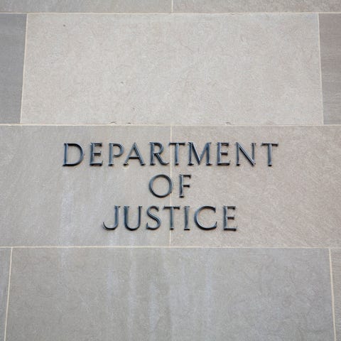 Department of Justice sign on a wall.
