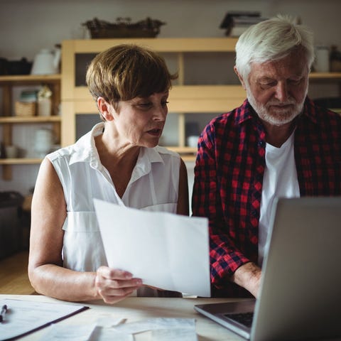 An older man and woman at a laptop.