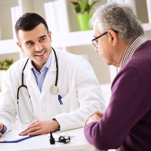 Older man talking with doctor.