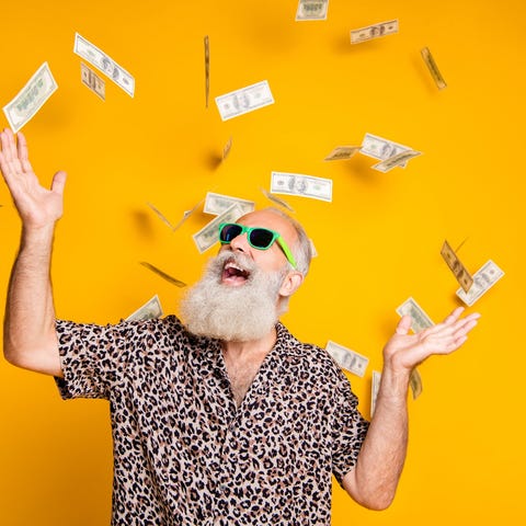 Senior man throwing dollar bills into the air