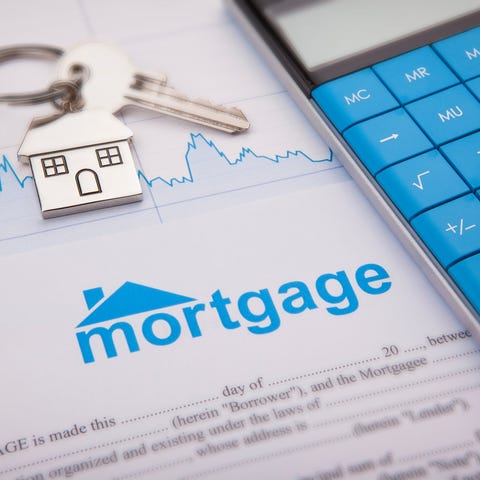 A mortgage document with a calculator and house ke