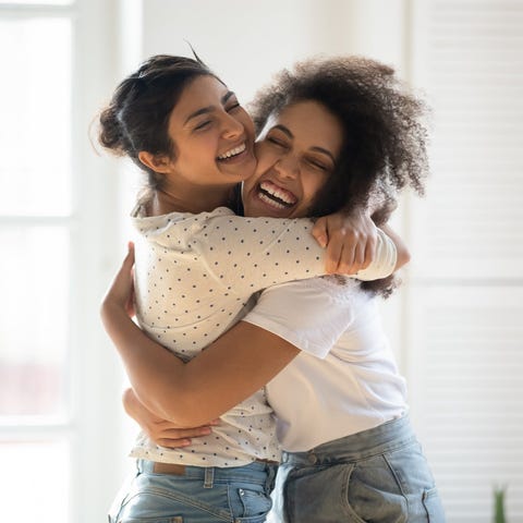 Two young people hugging indoors.