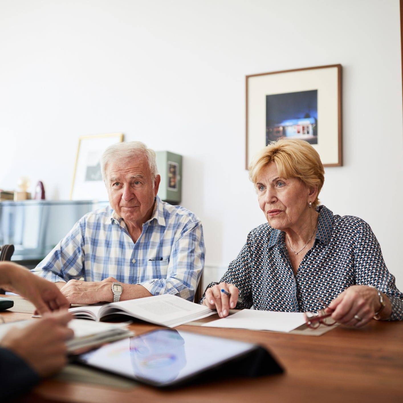 A couple sitting with an advisor going over taxes.
