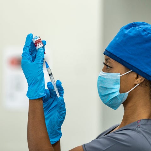 A healthcare professional holding a syringe and ne