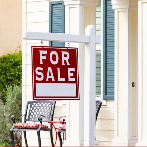 House with for sale sign in front of it.